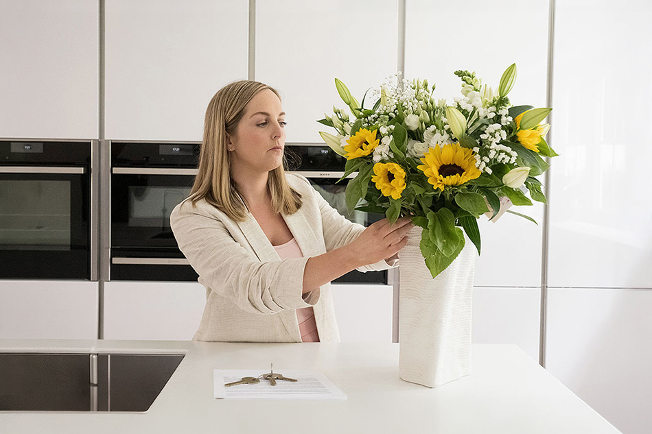 Alex Storey of Storeys Of Cheshire Estate Agents arranging flowers in a managed rental property